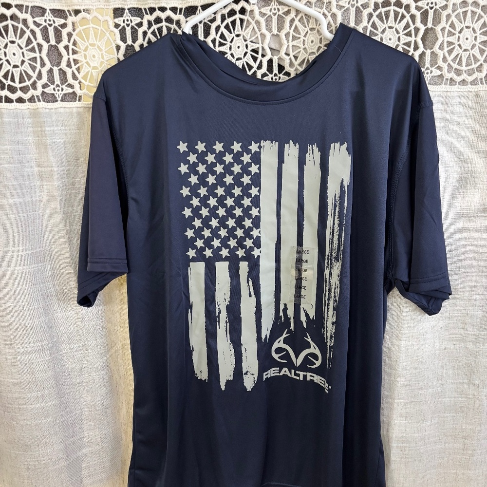 Real Tree Men’s Active Wear Short Sleeve Shirt   Blue With Flag Print. Size LG